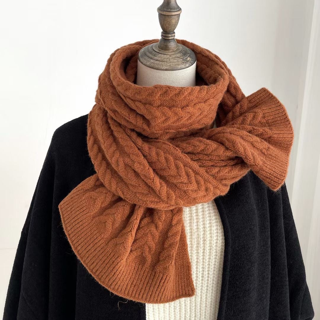 Écharpe en maille torsadée rouille, enroulée sur un manteau noir
